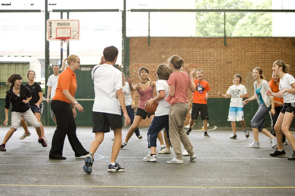 Students and staff playing basketball