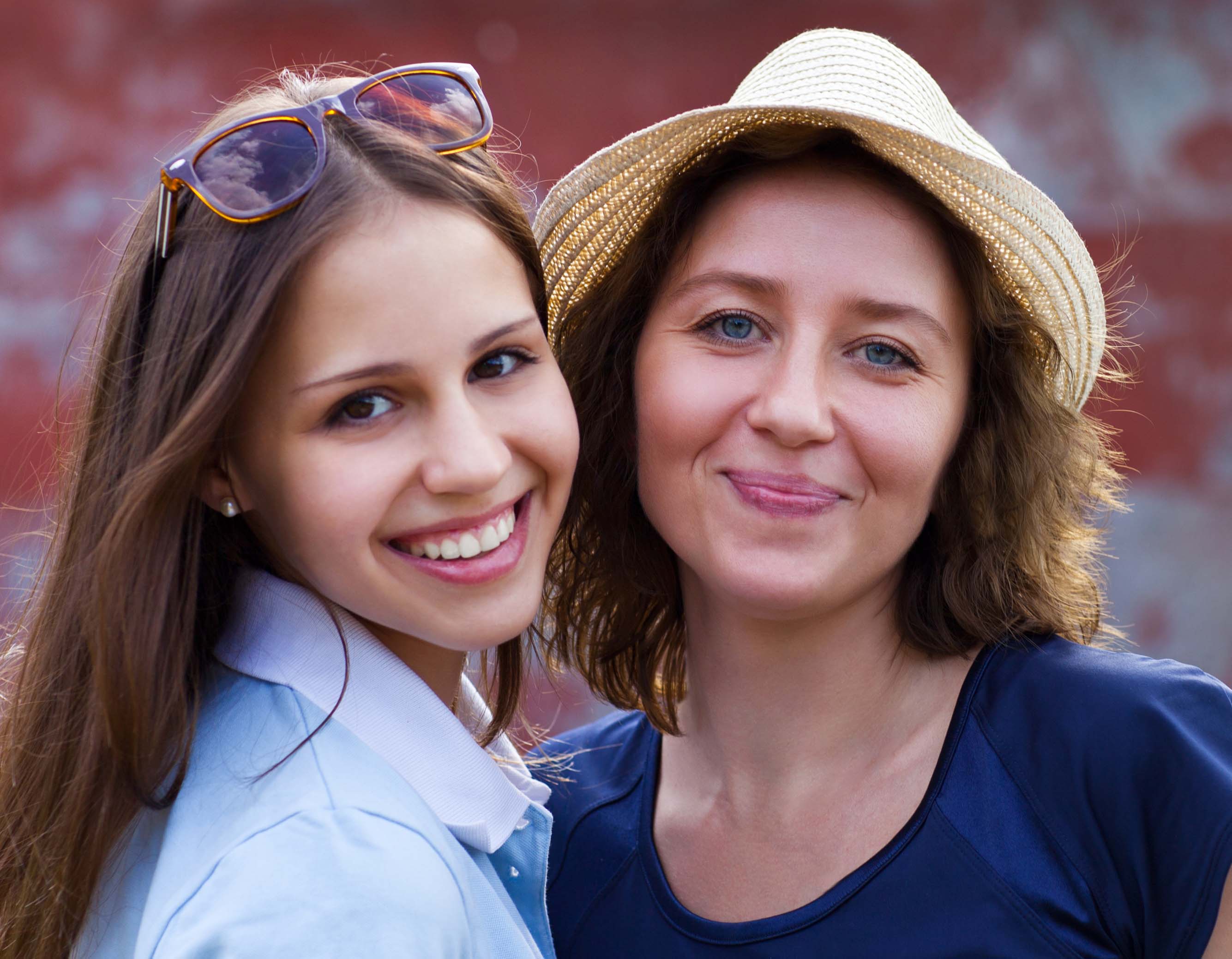 Young smiling woman with her teen daughter